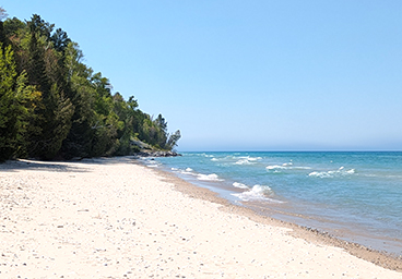 view of the beach at Cedar Cliff Cottage and the gentle waves on Lake Huron - looking north