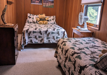 looking into bedroom two from the hallway of Cedar Cliff Cottage - double bed, twin bed, desser, window, tabletop fan