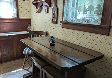 view of the dining room from the living room - dining room table with seating for four and two windows - at Cedar Cliff Cottage