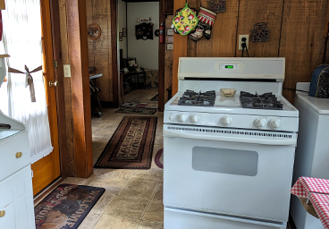 looking toward the dining from the kitchen at Cedar Cliff Cottage - door to outside on left, gas stove