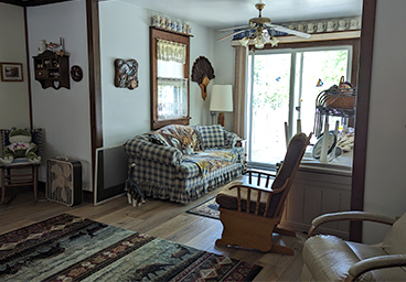 view of the living room looking toward the deck, past the cozy green plaid sofa at Cedar Cliff Cottage