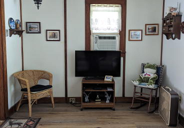 looking toward the television and two more chairs from the cushioned chairs in the living room of Cedar Cliff Cottage